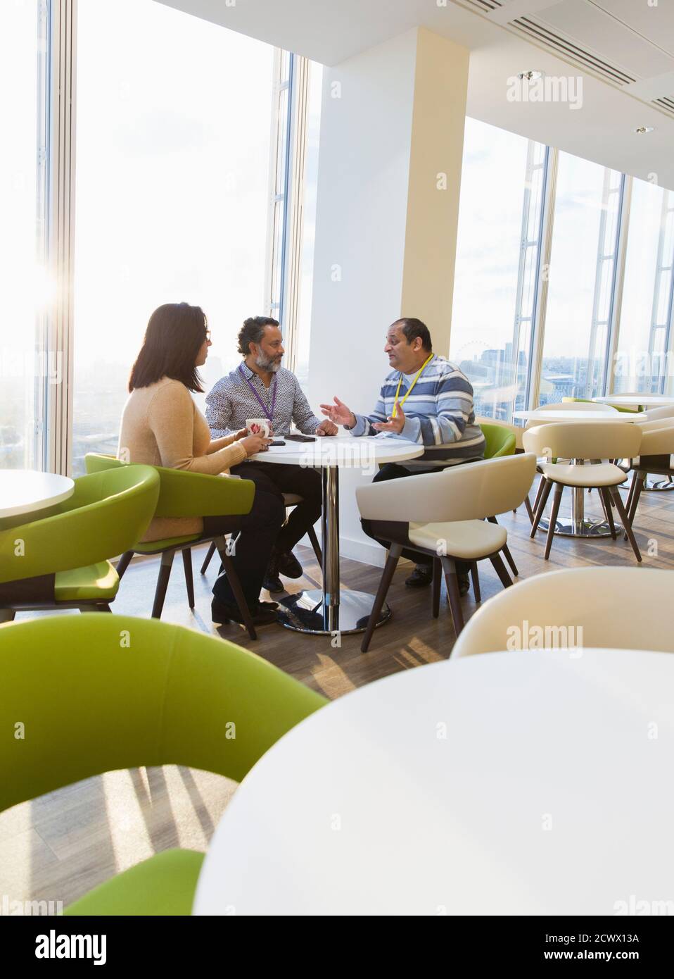 Geschäftsleute im sonnigen Büro Cafeteria sprechen Stockfoto