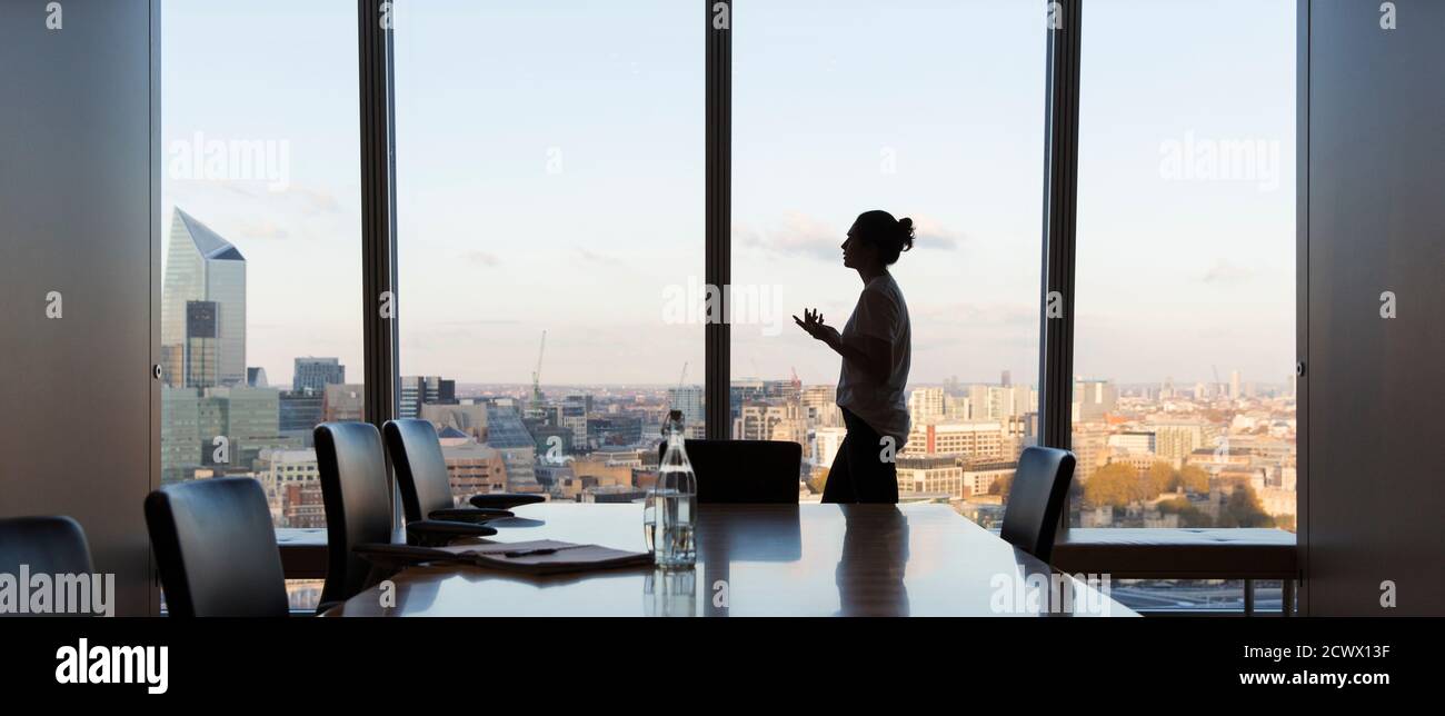 Geschäftsfrau, die sich auf das Treffen im Hochhaus-Konferenzraum vorbereitet Stockfoto