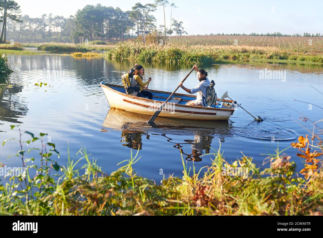 Junges Paar im Ruderboot auf sonnigem Fluss Stockfoto