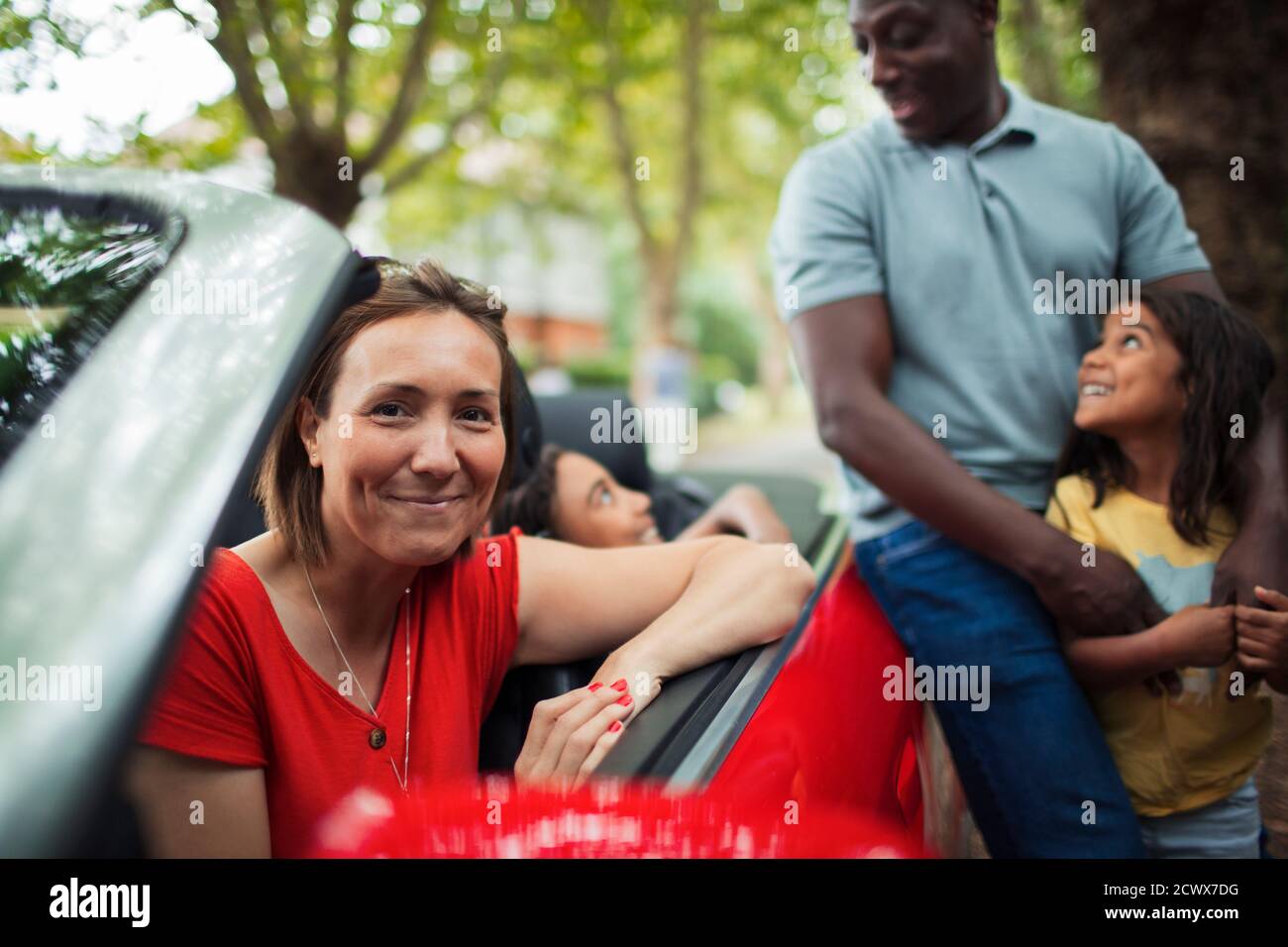 Portrait glückliche Frau mit Familie bei Cabrio Stockfoto