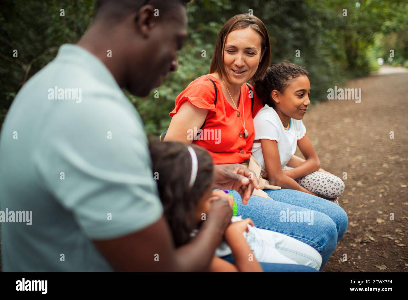 Glückliche Familie, die sich auf dem Weg im Park ausruhte Stockfoto