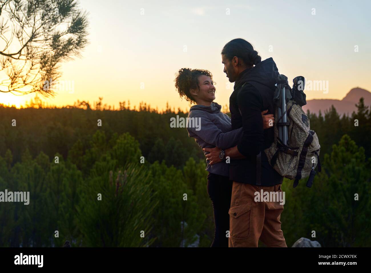 Liebevolles glückliches junges Wanderpaar in der Natur bei Sonnenuntergang Stockfoto