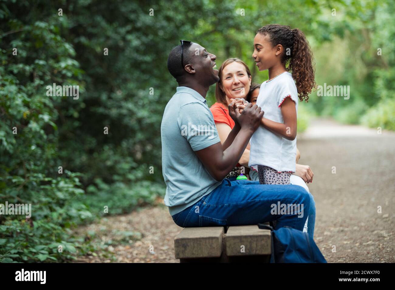 Glückliche Familie auf Parkbank Stockfoto