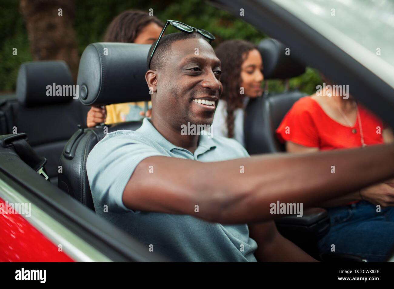 Glücklicher Mann fährt Cabrio mit Familie Stockfoto