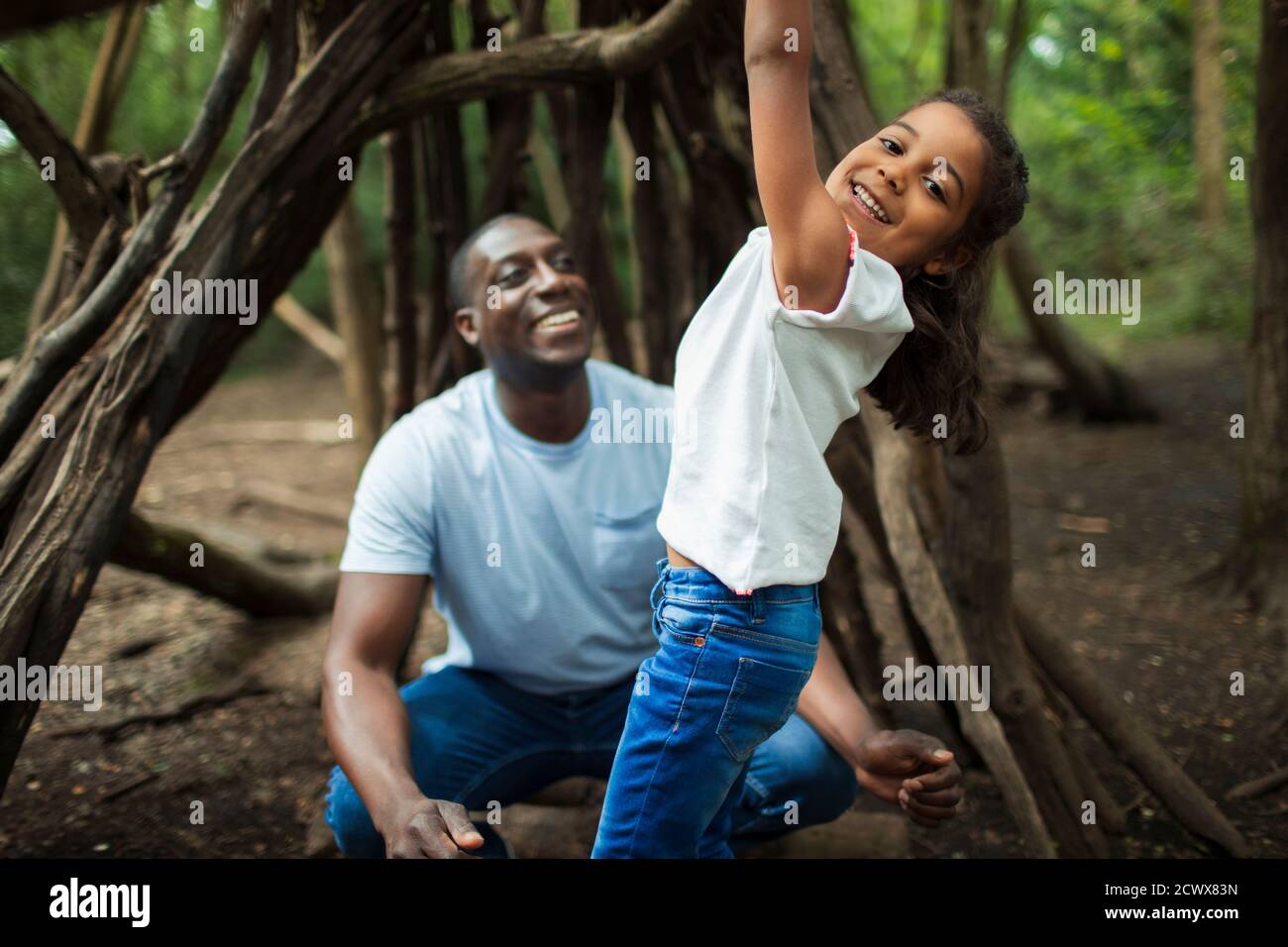 Portrait glücklicher Vater und Tochter spielen am Baum in Wäldern Stockfoto