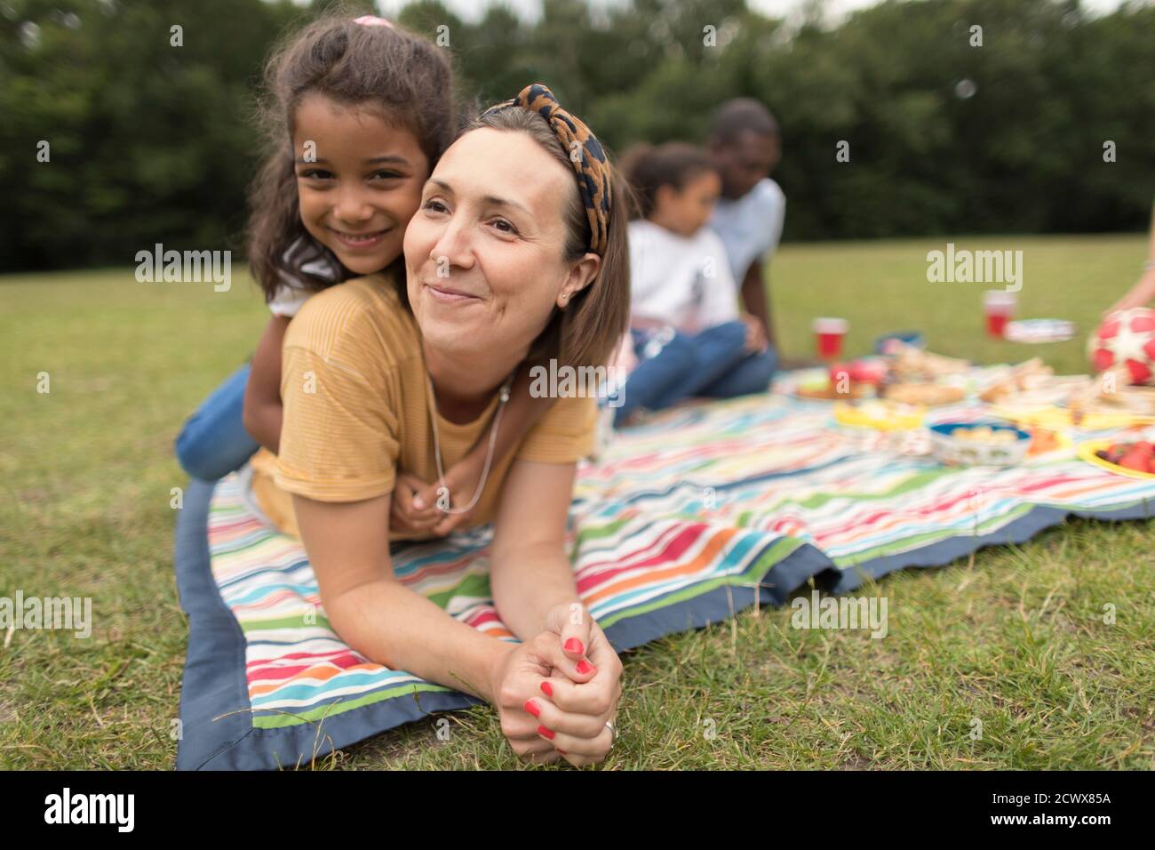 Portrait glückliche Mutter und Tochter entspannen auf Picknickdecke in parken Stockfoto