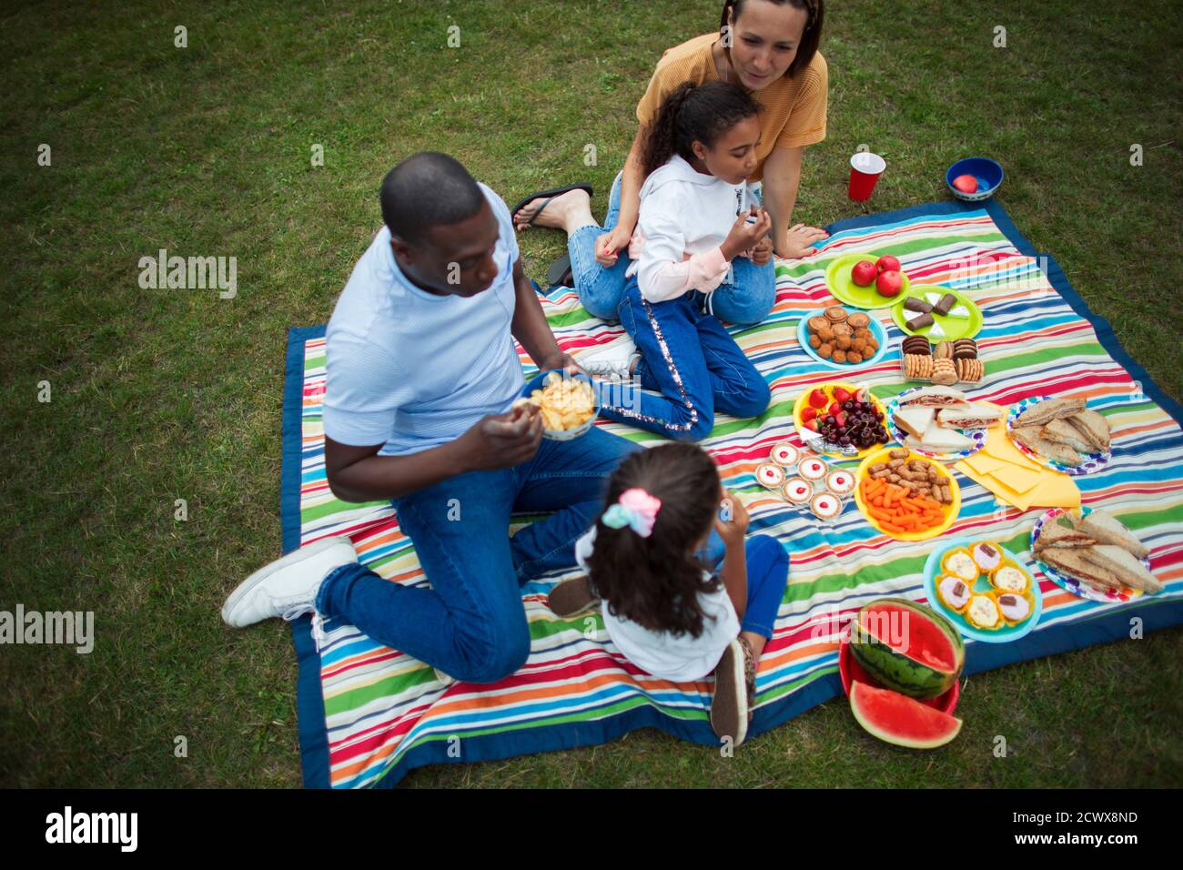 Familie genießt Picknick auf Decke im Park Stockfoto