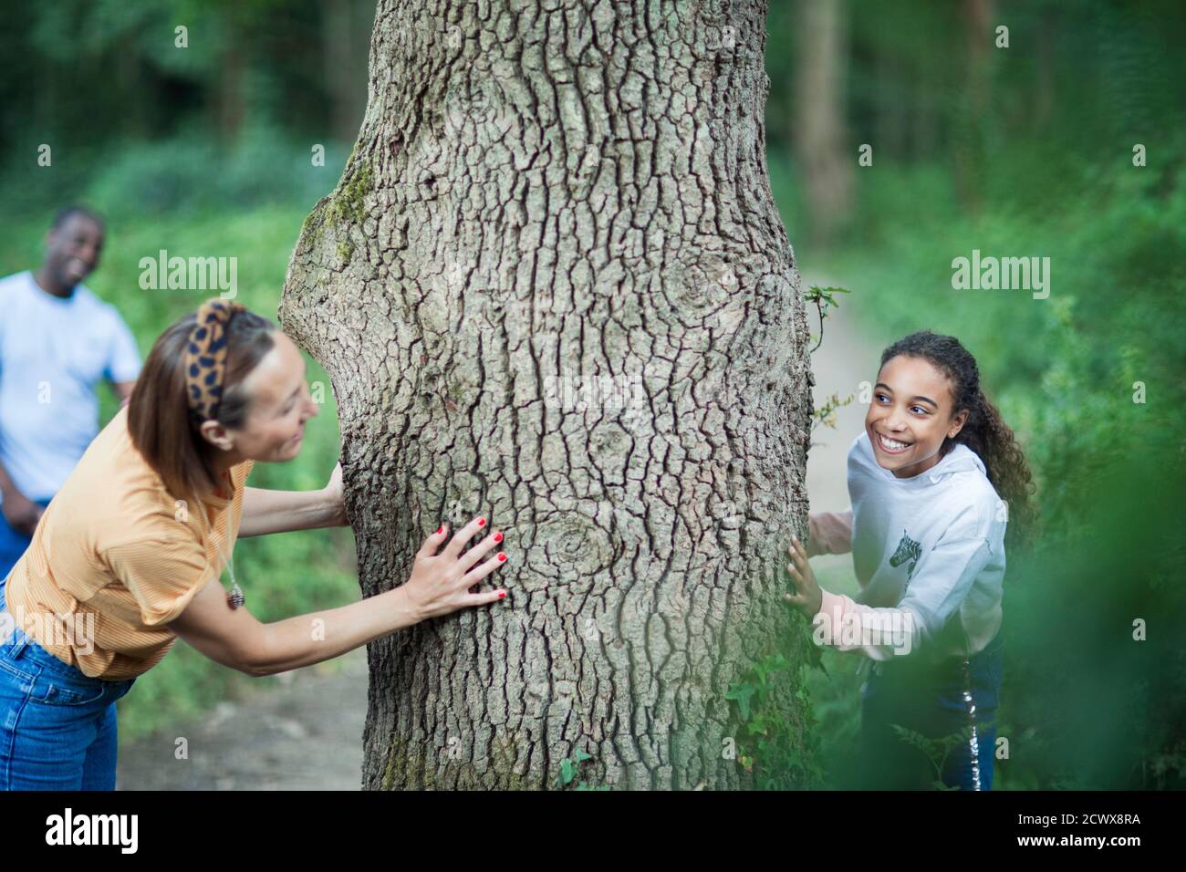 Verspielte Mutter und Tochter beim Baum in den Wäldern Stockfoto