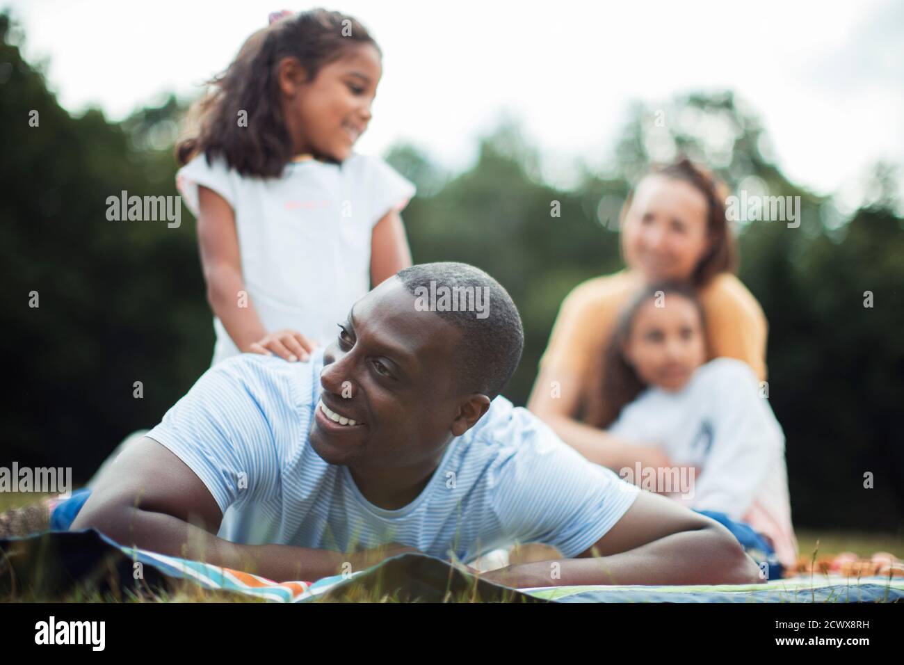 Glücklicher Mann genießt Picknick im Park mit der Familie Stockfoto
