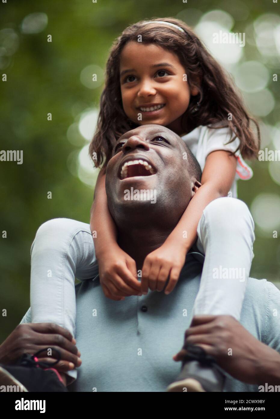 Glücklicher Vater Tochter auf den Schultern tragen Stockfoto