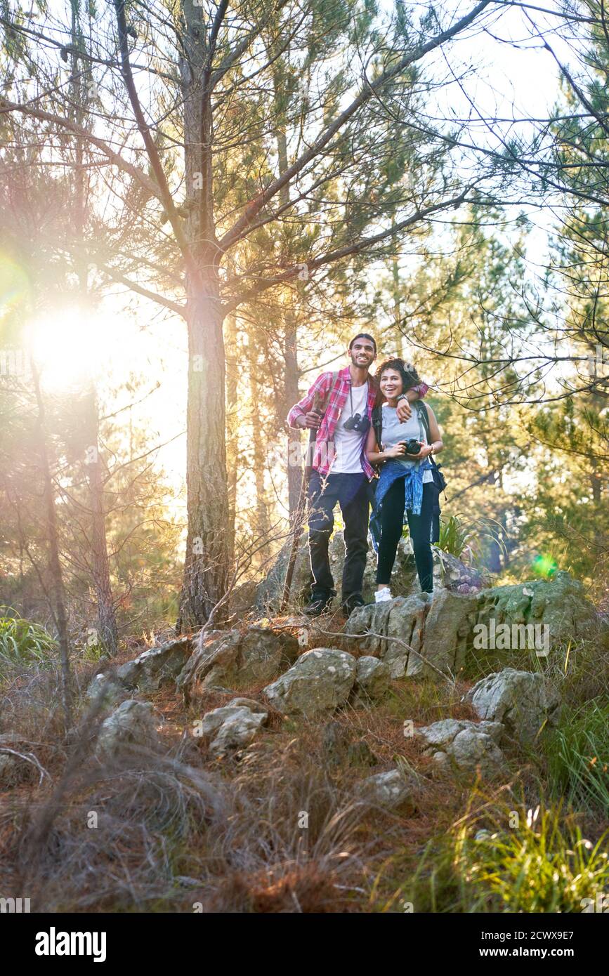 Glückliches junges Paar Wandern in sonnigen Wäldern Stockfoto