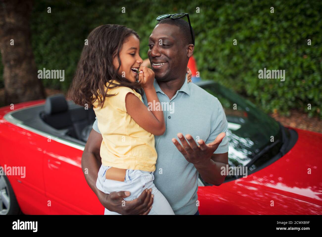 Glücklicher Vater hält Tochter von Cabrio Stockfoto