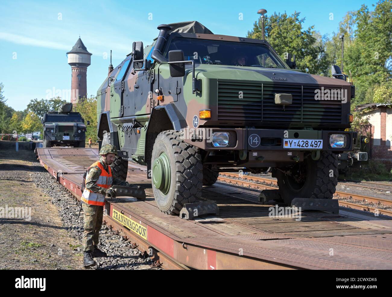 30. September 2020, Brandenburg, Wustermark/OT Elstal: Nachdem auf dem Gelände der Rail & Logistik Center Wustermark GmbH ein "ingo" auf einen Güterwagen verladen wurde, sichert ein Soldat das gepanzerte Fahrzeug mit Unterlegkeilen. Das Lpgistikbataillon Beelitz (Lpgistikbataillon Beelitz) der Bundeswehr probte als Soldatenlehrgang das Verladen verschiedener Fahrzeuge auf die Bahn. Nach Angaben der Firma war dies die erste Verladung von Militärfahrzeugen für den Rangierbahnhof nach dem Abzug der Roten Armee im Jahr 1992. Foto: Soeren Sache/dpa-Zentralbild/dpa Stockfoto