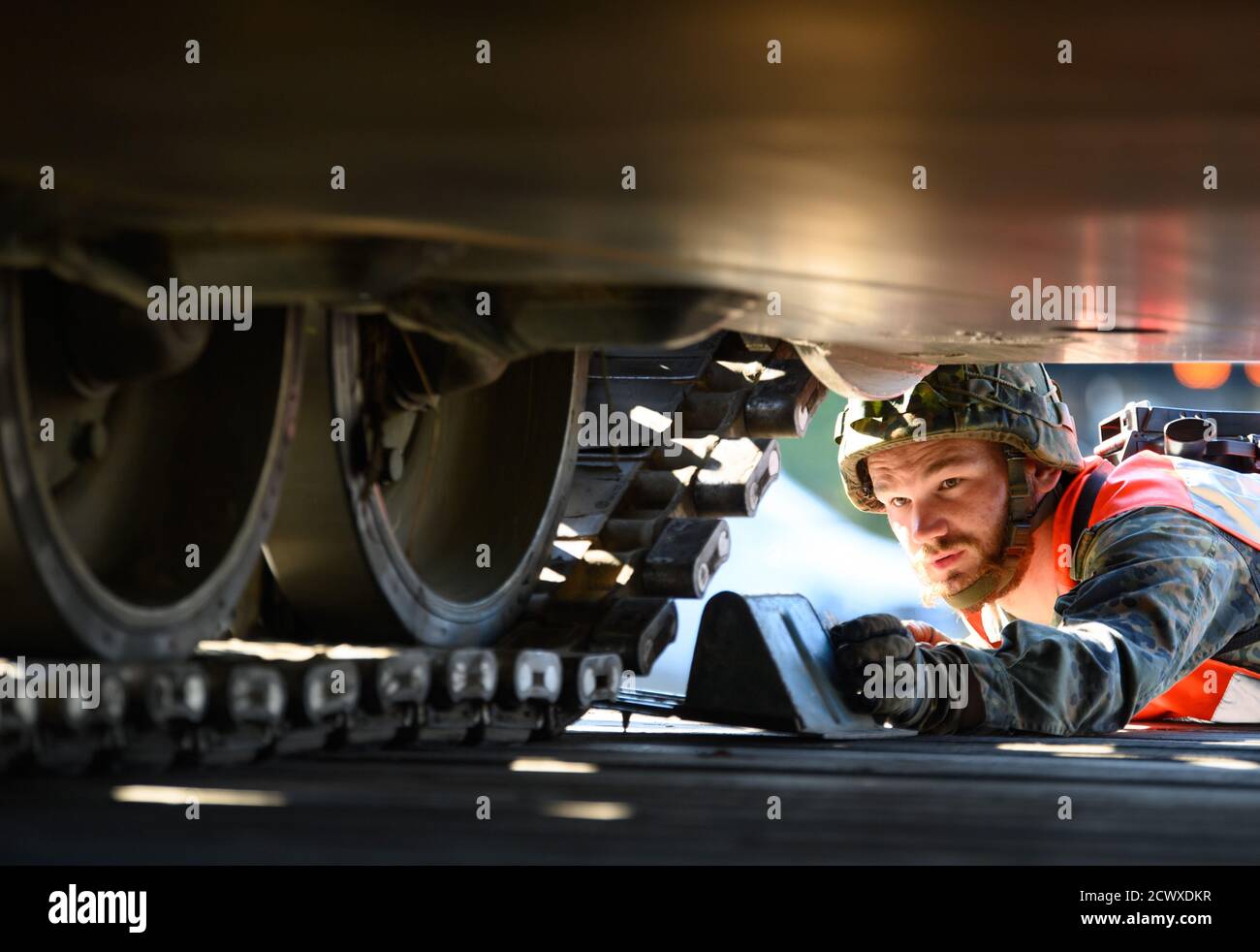 30. September 2020, Brandenburg, Wustermark/OT Elstal: Nachdem auf dem Gelände der Rail & Logistik Center Wustermark GmbH ein gepanzertes Rückholfahrzeug Leopard 1 auf einen Güterwagen verladen wurde, sicherte ein Soldat den Panzer mit Unterlegkeilen. Das Logistik-Bataillon Beelitz der Bundeswehr probte die Verladung verschiedener Fahrzeuge auf die Bahn als Soldatenausbildung. Nach Angaben der Firma war dies die erste Verladung von Militärfahrzeugen für den Rangierbahnhof nach dem Abzug der Roten Armee im Jahr 1992. Foto: Soeren Sache/dpa-Zentralbild/dpa Stockfoto