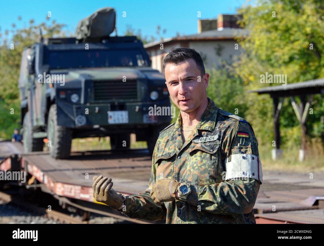 30. September 2020, Brandenburg, Wustermark/OT Elstal: Nachdem auf dem Gelände der Rail & Logistik Center Wustermark GmbH ein "ingo" auf einen Güterwagen verladen wurde, erläutert Kapitän Benjamin Drabsch den Ablauf. Das Logistik-Bataillon Beelitz der Bundeswehr probte die Verladung verschiedener Fahrzeuge auf die Bahn als Soldatenausbildung. Nach Angaben der Firma war dies die erste Verladung von Militärfahrzeugen für den Rangierbahnhof nach dem Abzug der Roten Armee im Jahr 1992. Foto: Soeren Sache/dpa-Zentralbild/dpa Stockfoto