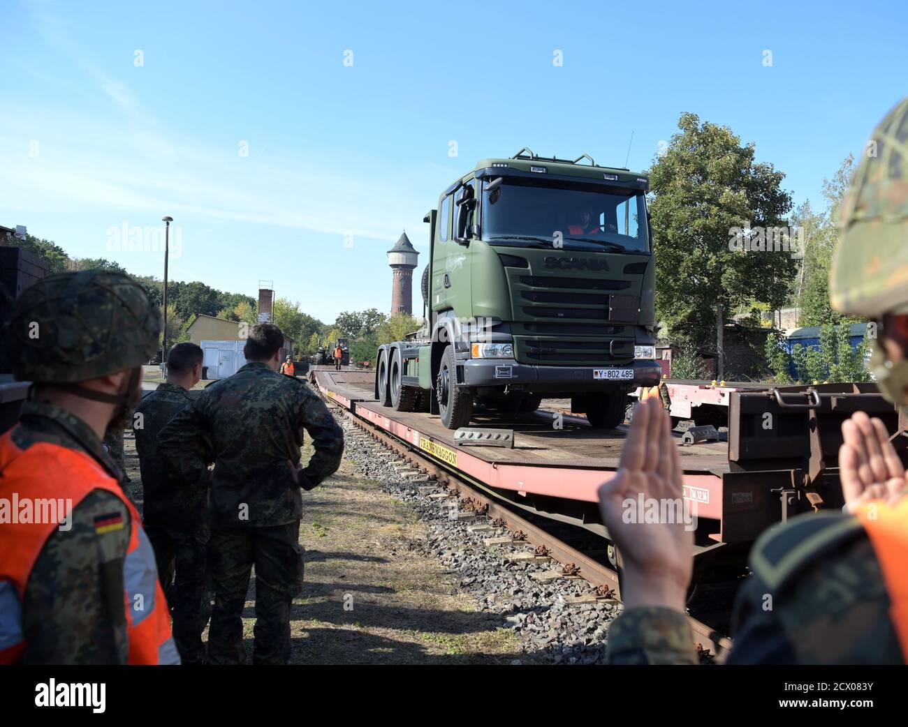 30. September 2020, Brandenburg, Wustermark/OT Elstal: Auf dem Gelände der Rail & Logistik Center Wustermark GmbH fährt ein LKW auf einen Güterwagen und wird von einem Soldaten beauftragt. Das Lpgistikbataillon Beelitz der Bundeswehr probte das Verladen verschiedener Fahrzeuge auf die Bahn als Soldatentraining. Nach Angaben der Firma war dies die erste Verladung von Militärfahrzeugen für den Rangierbahnhof nach dem Abzug der Roten Armee im Jahr 1992. Foto: Soeren Sache/dpa-Zentralbild/ZB Stockfoto