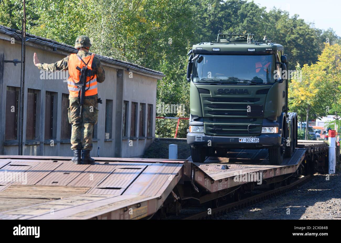 30. September 2020, Brandenburg, Wustermark/OT Elstal: Auf dem Gelände der Rail & Logistik Center Wustermark GmbH fährt ein LKW auf einen Güterwagen und wird von einem Soldaten beauftragt. Das Lpgistikbataillon Beelitz der Bundeswehr probte das Verladen verschiedener Fahrzeuge auf die Bahn als Soldatentraining. Nach Angaben der Firma war dies die erste Verladung von Militärfahrzeugen für den Rangierbahnhof nach dem Abzug der Roten Armee im Jahr 1992. Foto: Soeren Sache/dpa-Zentralbild/ZB Stockfoto