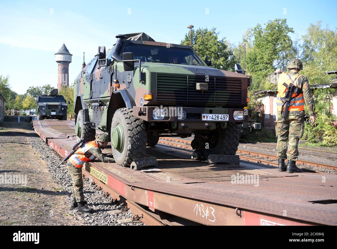 30. September 2020, Brandenburg, Wustermark/OT Elstal: Nachdem auf dem Gelände der Rail & Logistik Center Wustermark GmbH ein "ingo" auf einen Güterwagen verladen wurde, sichert ein Soldat das gepanzerte Fahrzeug mit Unterlegkeilen. Das Lpgistikbataillon Beelitz (Lpgistikbataillon Beelitz) der Bundeswehr probte als Soldatenlehrgang das Verladen verschiedener Fahrzeuge auf die Bahn. Nach Angaben der Firma war dies die erste Verladung von Militärfahrzeugen für den Rangierbahnhof nach dem Abzug der Roten Armee im Jahr 1992. Foto: Soeren Sache/dpa-Zentralbild/ZB Stockfoto
