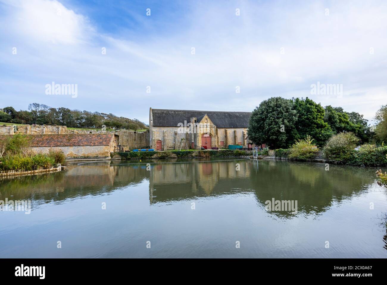 Die große Zehenscheune und der Teich an den Ruinen der Abbotsbury Abbey, einem ehemaligen Benediktinerkloster in Abbotsbury, Devon, Südostengland Stockfoto