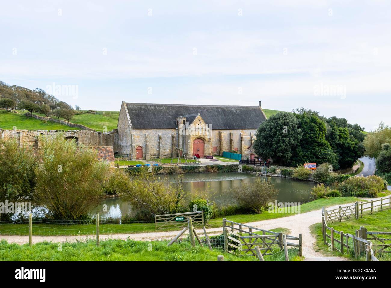 Die große Zehenscheune und der Teich an den Ruinen der Abbotsbury Abbey, einem ehemaligen Benediktinerkloster in Abbotsbury, Devon, Südostengland Stockfoto
