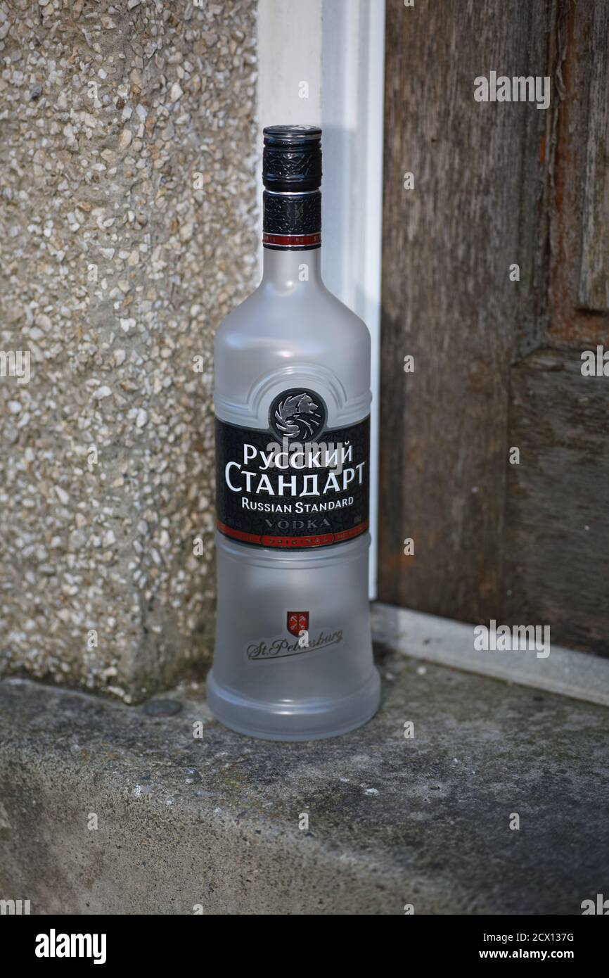 Leere Wodka-Flasche vor der Haustür. Stockfoto