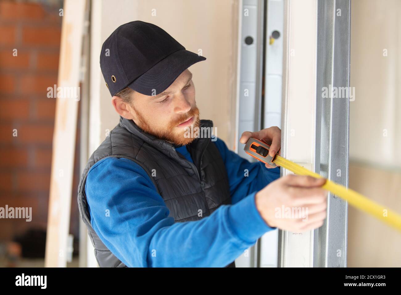 Der Service-Mann installiert Fenster am Baugebäude Stockfoto