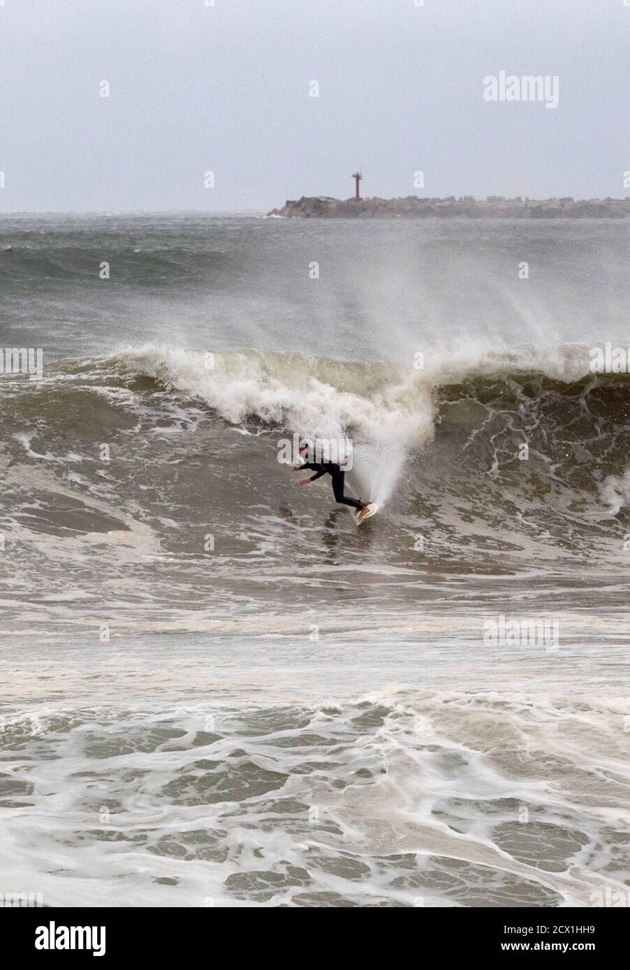 Eine Surfer nutzt große Wellen, verursacht durch den Hurrikan Irina das einige 200 Seemeilen (370 km) vor Durban, 5. März 2012 sitzt. REUTERS/Rogan Ward (Südafrika - Tags: SPORT Umwelt) Stockfoto