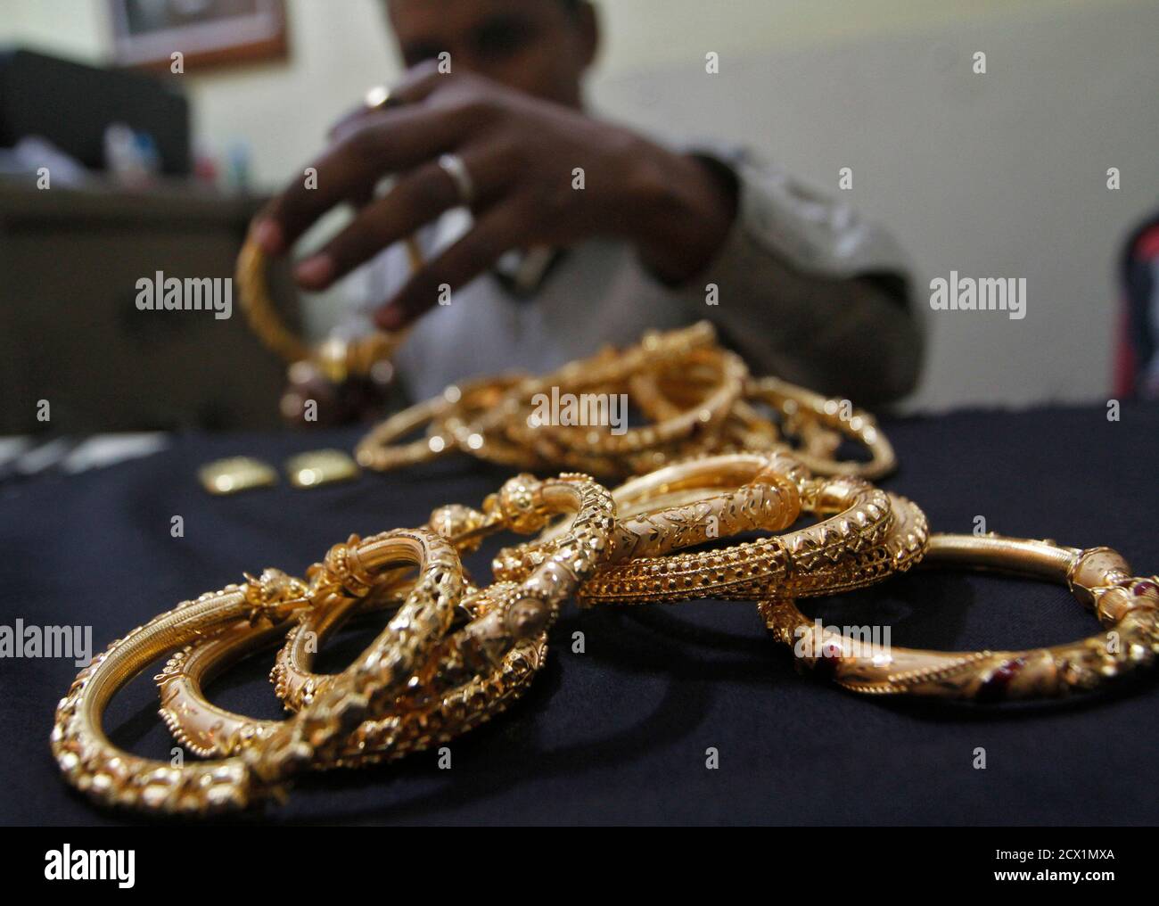 Eine Goldschmied hält fertigen gold Armreifen bei einem Workshop in Kolkata 16. Januar 2013. Indiens Leidenschaft für Gold ist dabei so zu belasten Staatsfinanzen, dass die Regierung höheren Einfuhrzöllen auf Edelmetall, aber Nachfrage beflügelt durch berauschende Inflation schlagen und mageren Ersparnisse stumpf die Auswirkungen jeder Anstieg der Aufgaben kann werden. REUTERS/Rupak De Chowdhuri (Indien - Tags: BUSINESS-Rohstoffe) Stockfoto