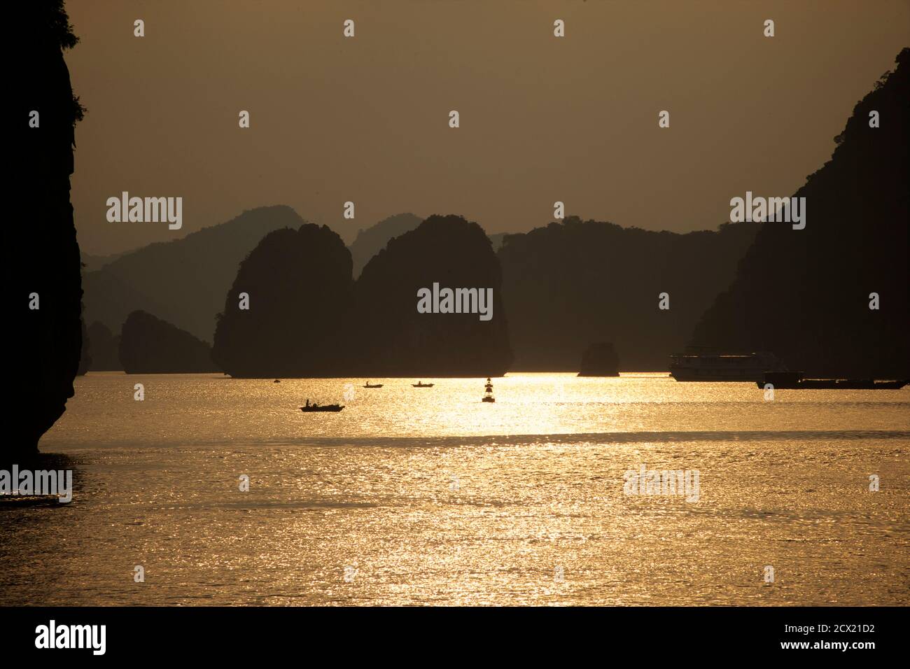 Boote in der Ha Long Bay bei Sonnenuntergang, Vietnam Stockfoto