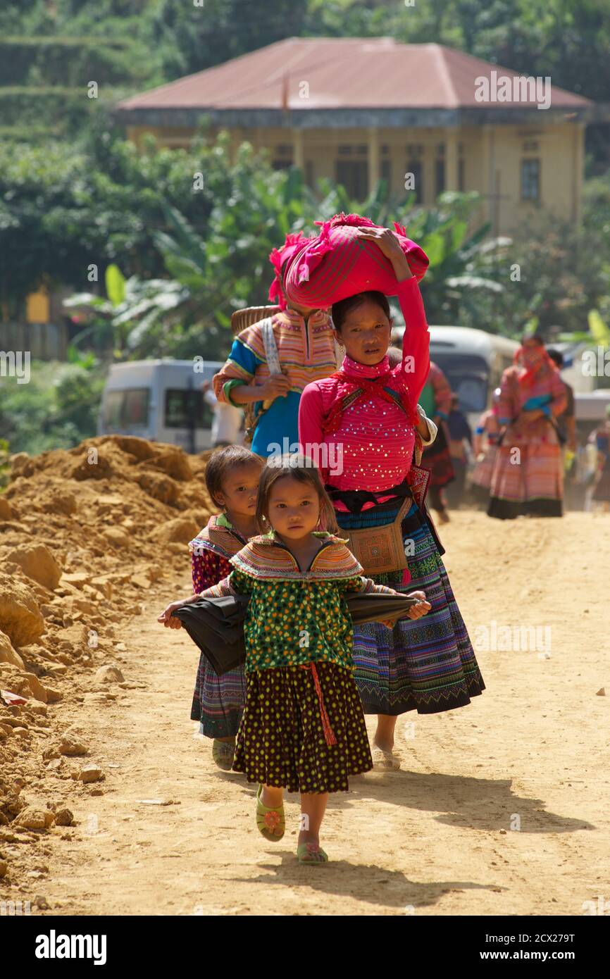 Hmong Mutter und Kinder zu Fuß in Can CAU Markt, in der Nähe Bac Ha, Lao Cai Provinz, Vietnam Stockfoto
