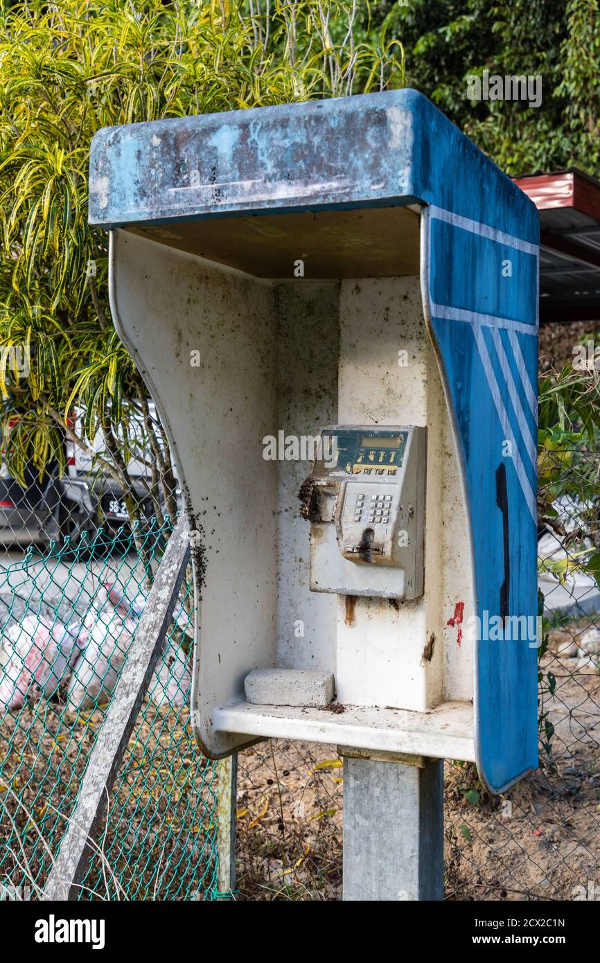 Kiau, Sabah, Malaysia: Untergegangene und zerstörte münzbetriebene öffentliche Telefonanlage in der Nähe von SK Kiau, der Grundschule des Dorfes. Stockfoto