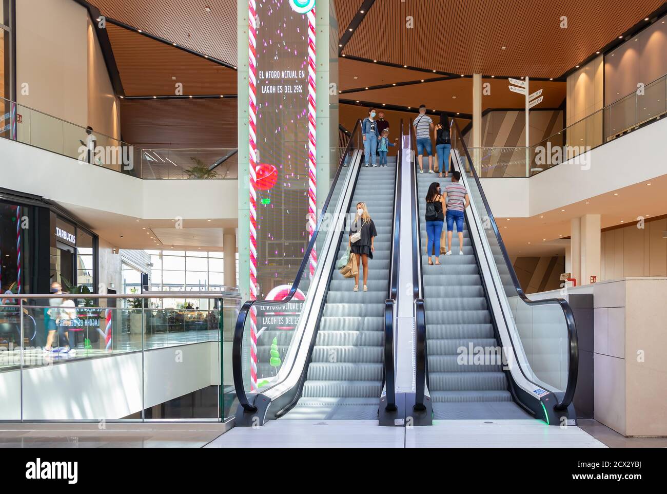 Sevilla, Spanien - 18. September 2020: Menschen an der automatischen Treppe des Lagoh Shopping Centers tragen Schutzmaske wegen Coronavirus covid-19. Neue Norm Stockfoto