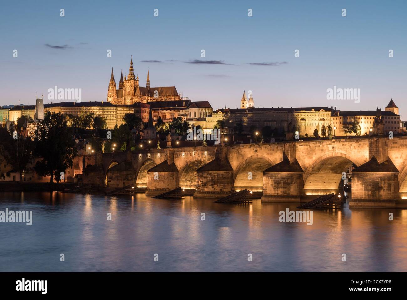 Karlsbrücke in Prag über die Moldau mit dem Veitsdom und der Prager Burg, ein Stadtbild in romantischer Dämmerung Stockfoto