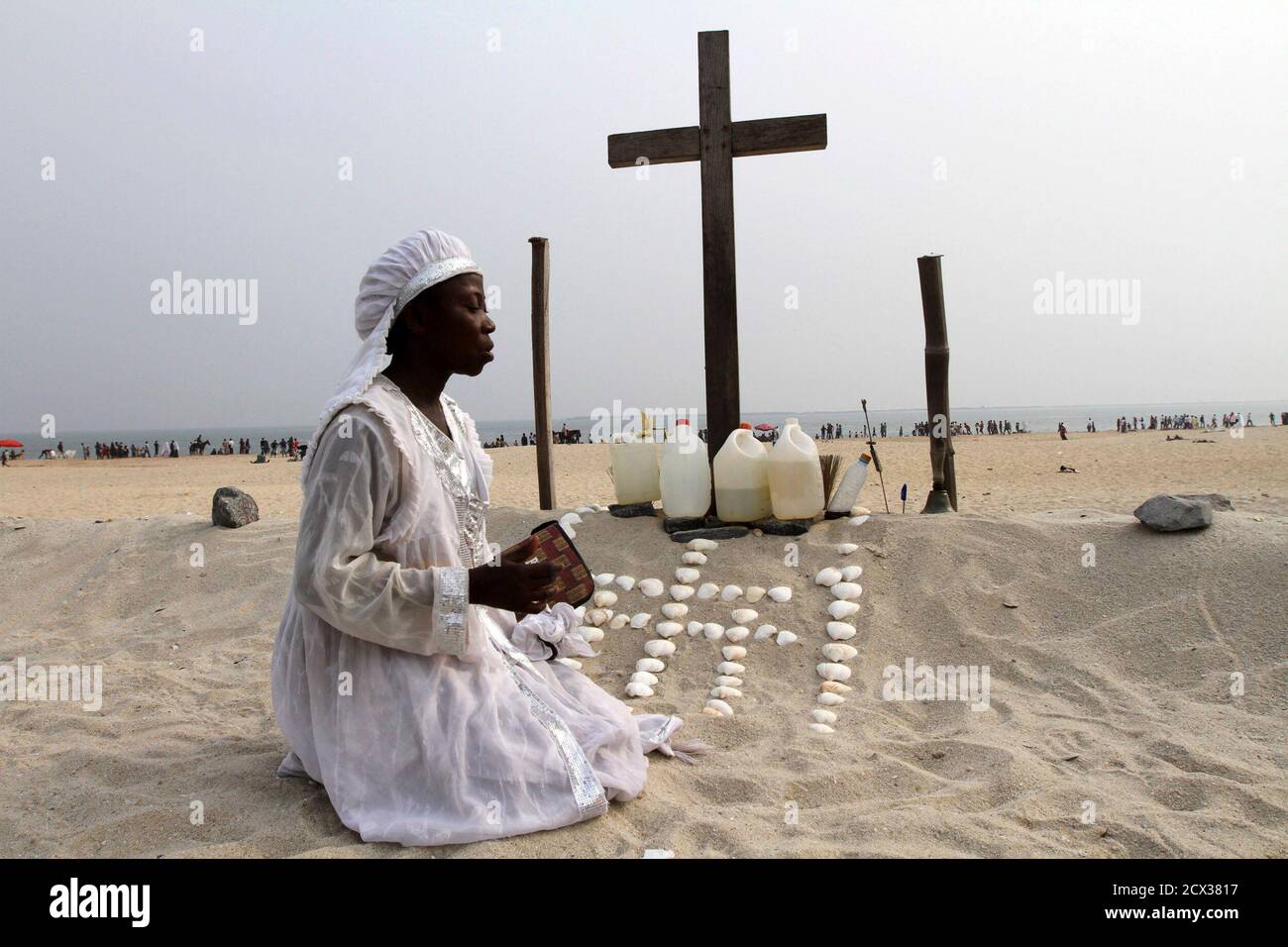 Ein Mitglied der weißen Kleidung Christian Sekte betet an einem Kreuz an  der Bar Strand, wo sie leben und beten in provisorischen Zelten, in Lagos  25. Dezember 2011. REUTERS/AKINTUNDE AKINLEYE (NIGERIA -