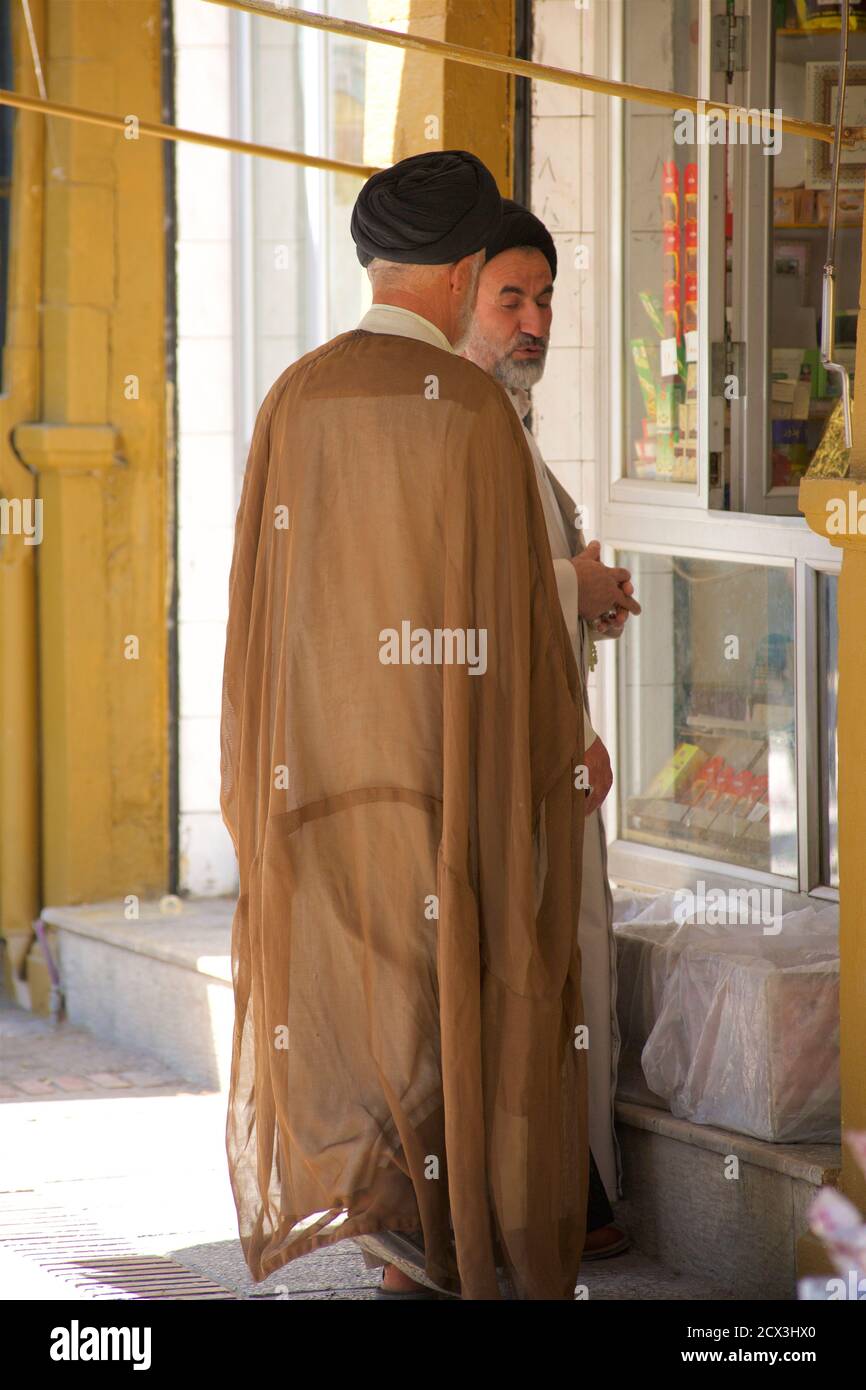 Islamische Theologen im Gespräch vor einem Geschäft. Shiraz, Iran Stockfoto