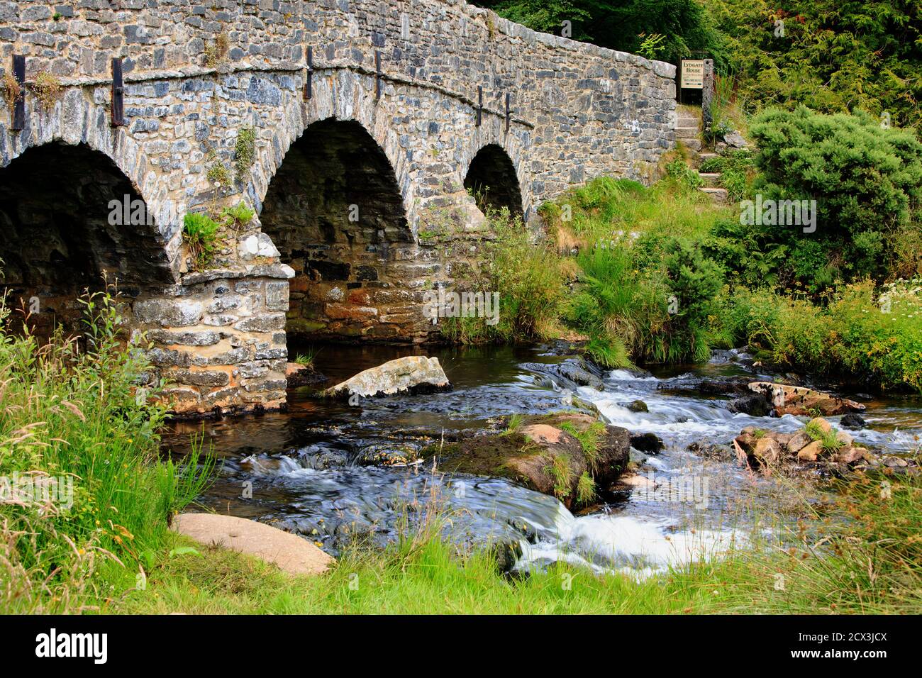 Postbridge in Dartmoor ist eine Fussgänger- und Fahrzeugbrücke, die sich überspannt Der kleine Bach unten Stockfoto