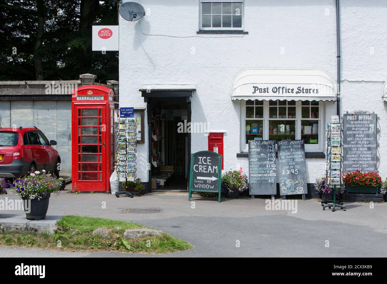 Ein altes traditionelles Postamt mit einem roten Telefon Box und verschiedene Werbetafeln in der Mitte des Landschaft in Dartmoor National Par Stockfoto