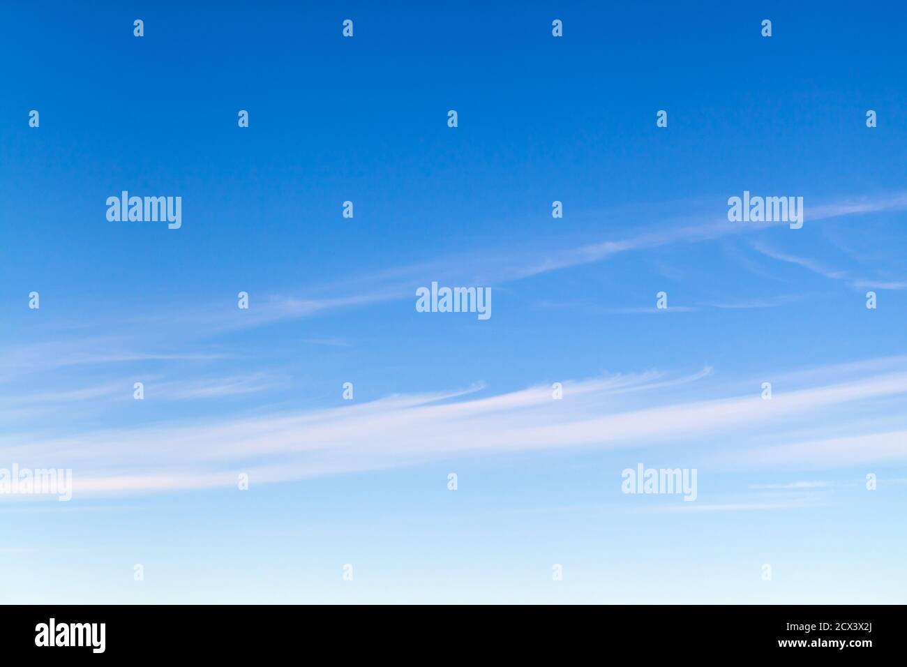 Blauer Himmel mit Streifen von Zirruswolken am Tag, natürliche Hintergrund Foto Textur Stockfoto