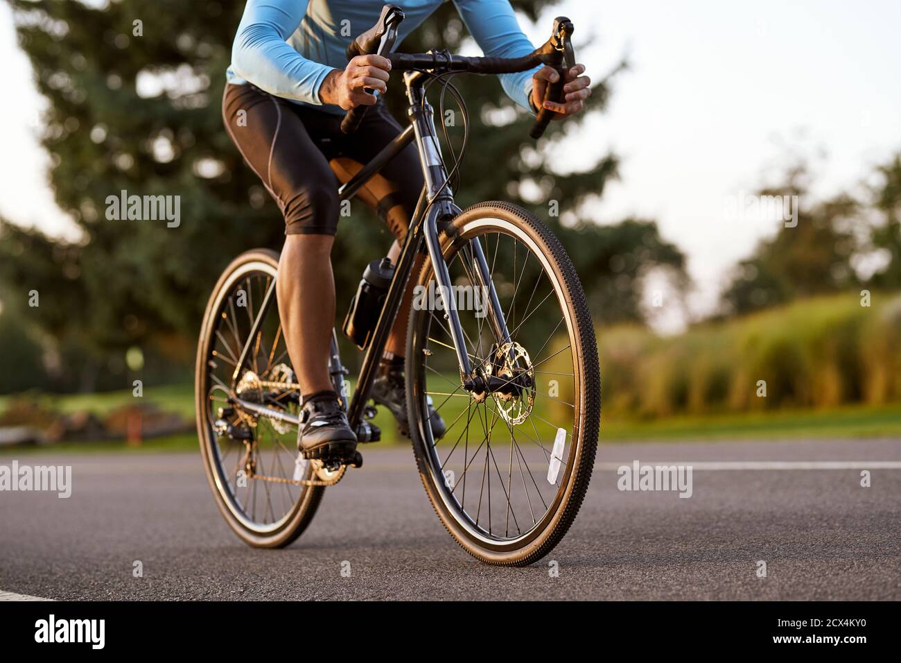 Kurzer Schuss eines Rennradfahrers in Sportbekleidung Radfahren im Park an einem Sommertag. Radfahren im Freien. Aktiver Lebensstil und Sport Stockfoto