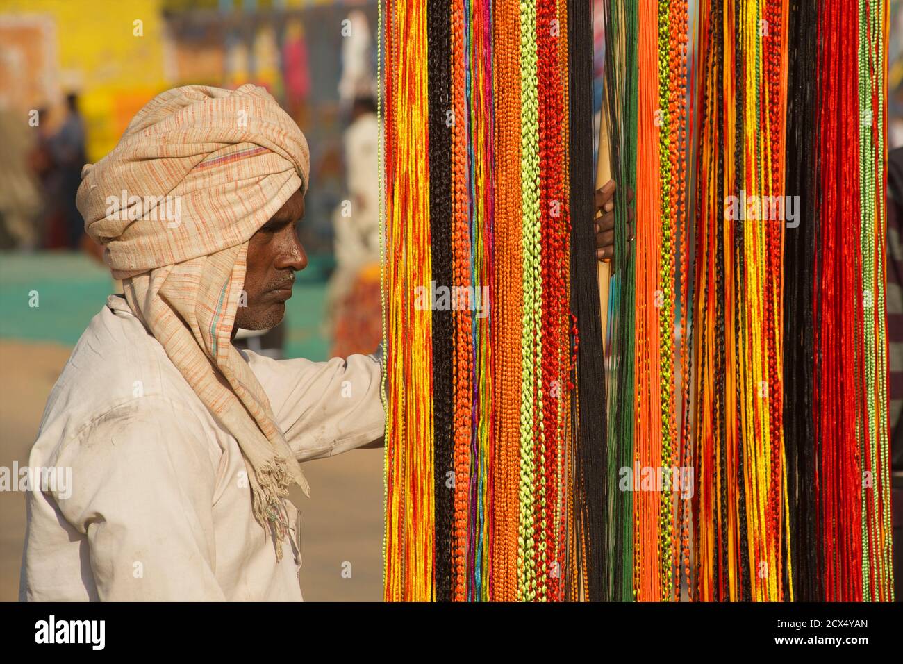Rajasthani Mann Verkauf bunte Zöpfe, Pushkar, Rajasthan, Indien Stockfoto