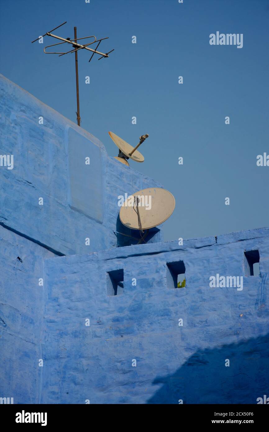 Satellitenschüsseln und Fernsehantenne. Blaue Wände und blauer Himmel. Jodhpur, Rajasthan, Indien Stockfoto