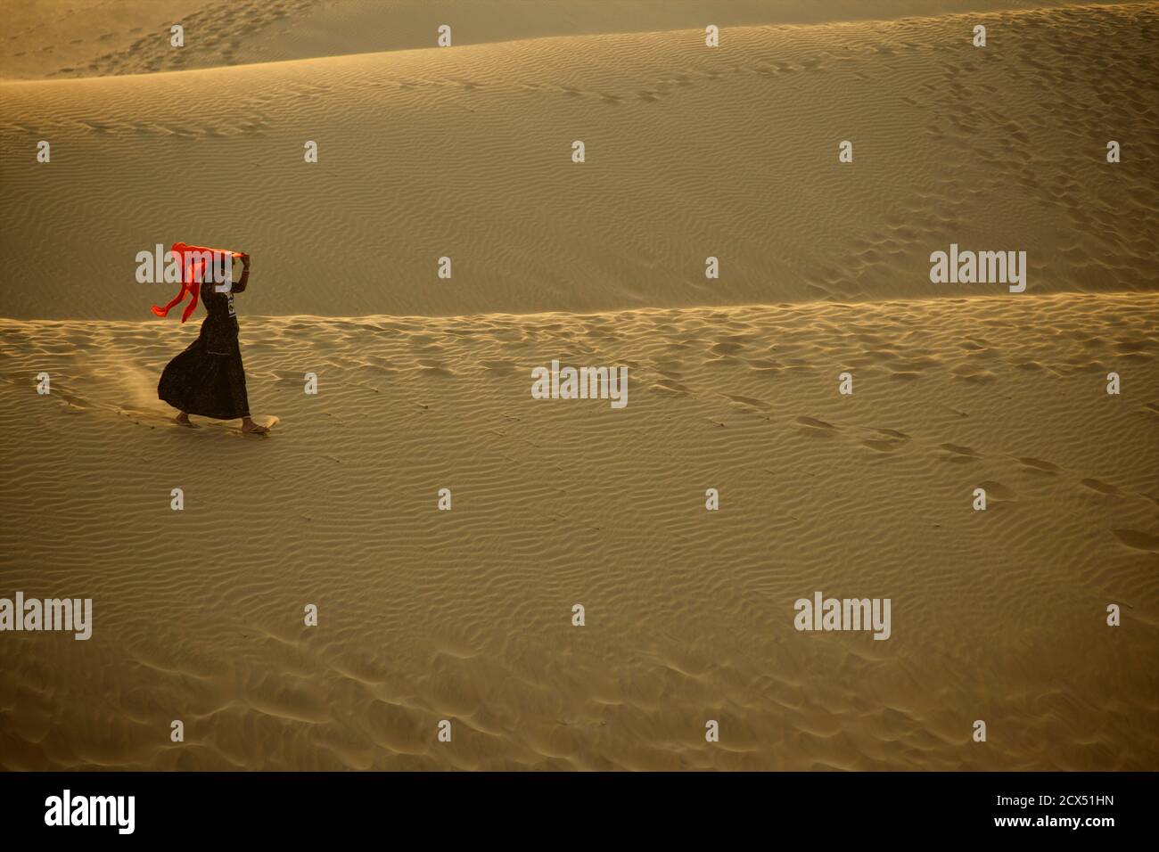 Frau in Sari zu Fuß über Dünen bei Sam, Thar Desert, Jaisalmer, Rajasthan, Indien Stockfoto