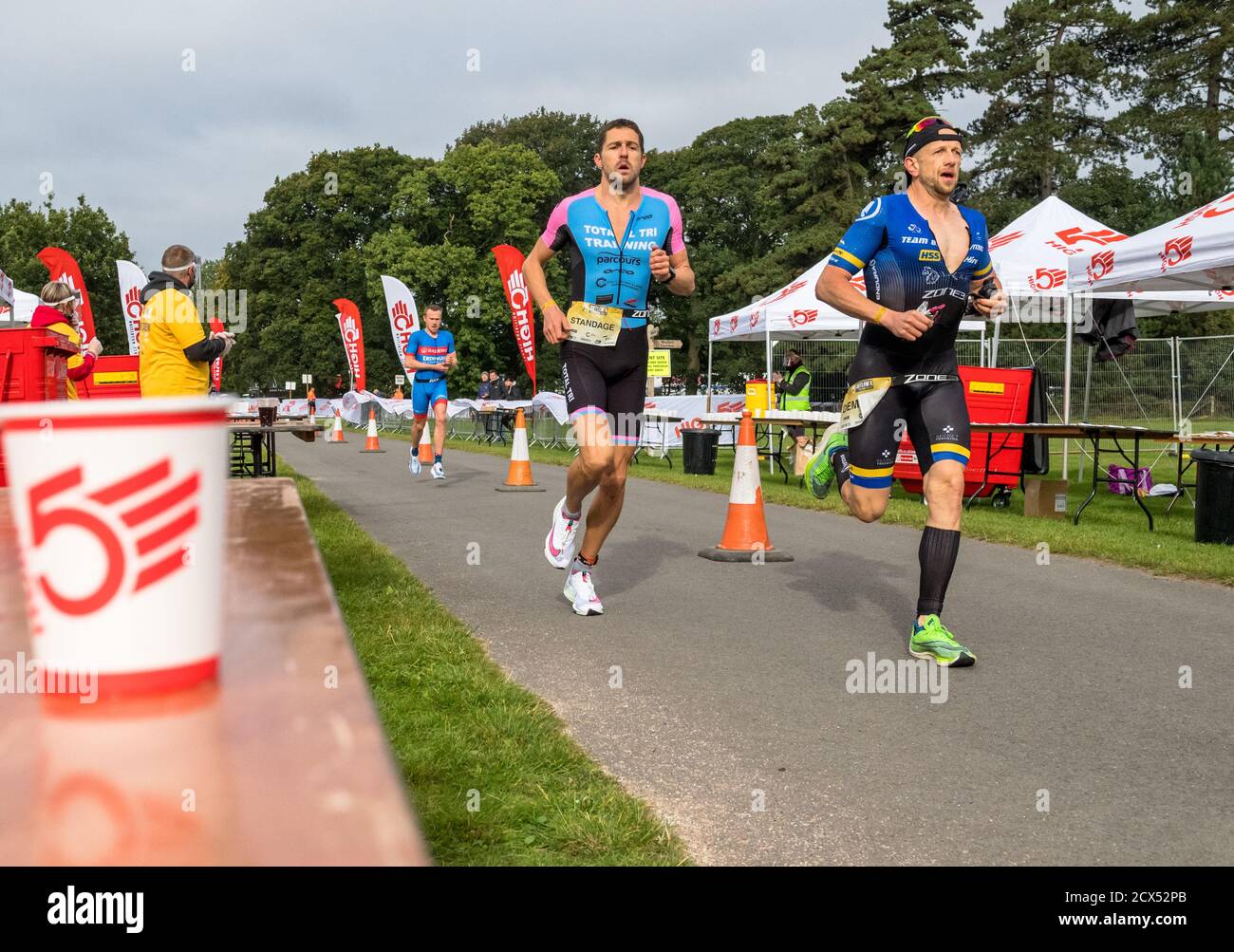 Männliche Athleten, die beim letzten Event des Jahres beim Thoresby Park X Outlaw Triathlon durch die Food Station laufen. Stockfoto