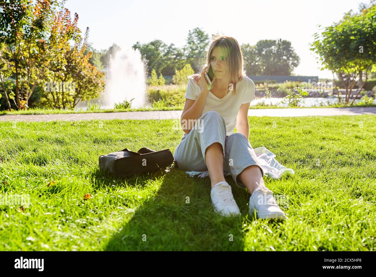 Traurige Junge Frau Die Allein Im Park Sitzt Und Ernste Anrufe Macht Stockfotografie Alamy