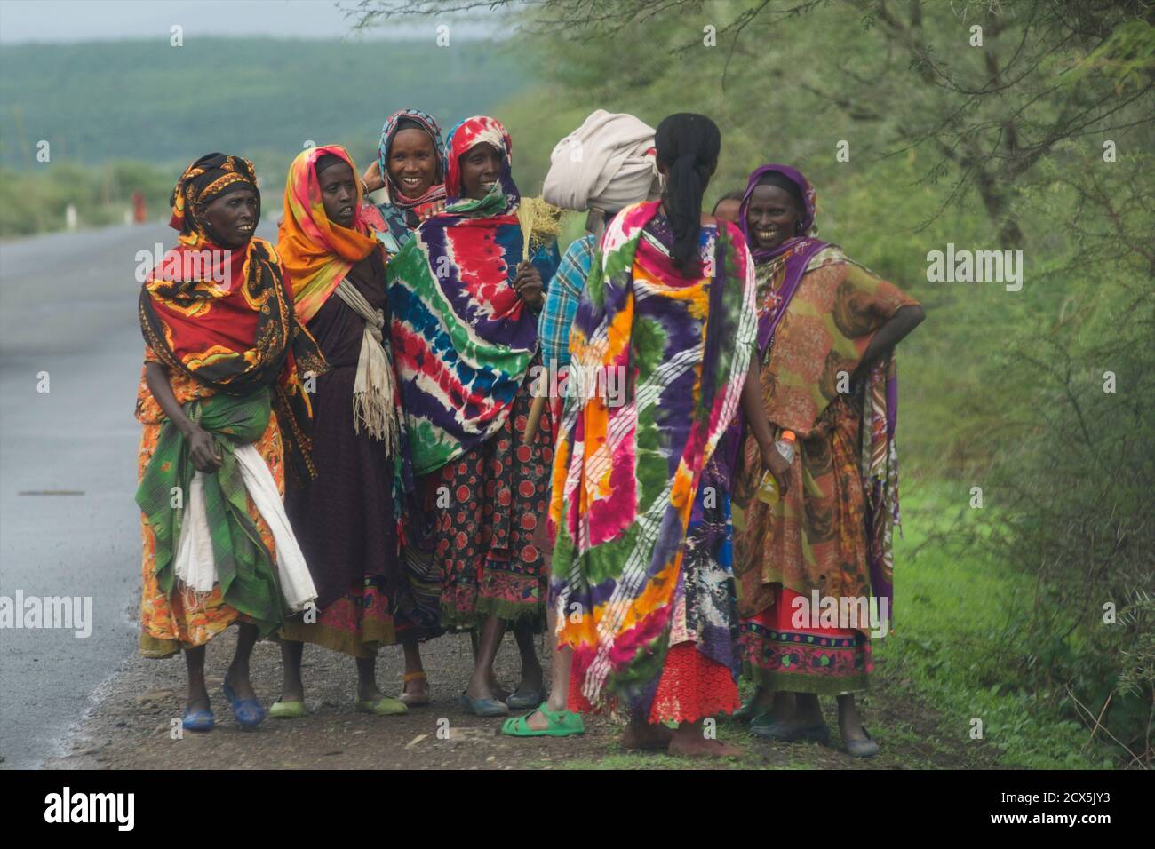 Oromo Frauen in farbenfroher Kleidung warten an der Straße, Oromia Region, Äthiopien. Stockfoto