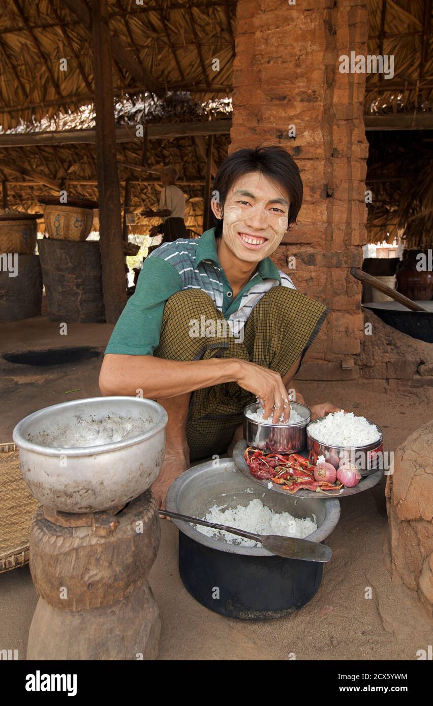 Burmesischer Mann mit unverwechselbaren Burmese Make-up genannt Thanaka auf seinem Gesicht Vorbereitung einer Mahlzeit. Birma Stockfoto
