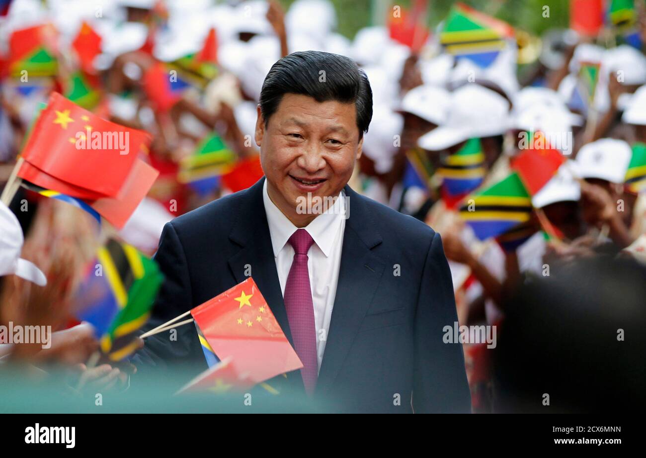 Chinas Präsident Xi Jinping durchschreitet tansanische Frauen wehende  Fahnen, wie er an das State House in Dar Es Salaam, 24. März 2013. XI steht  mehren sich die Rufe von Politikern und Ökonomen