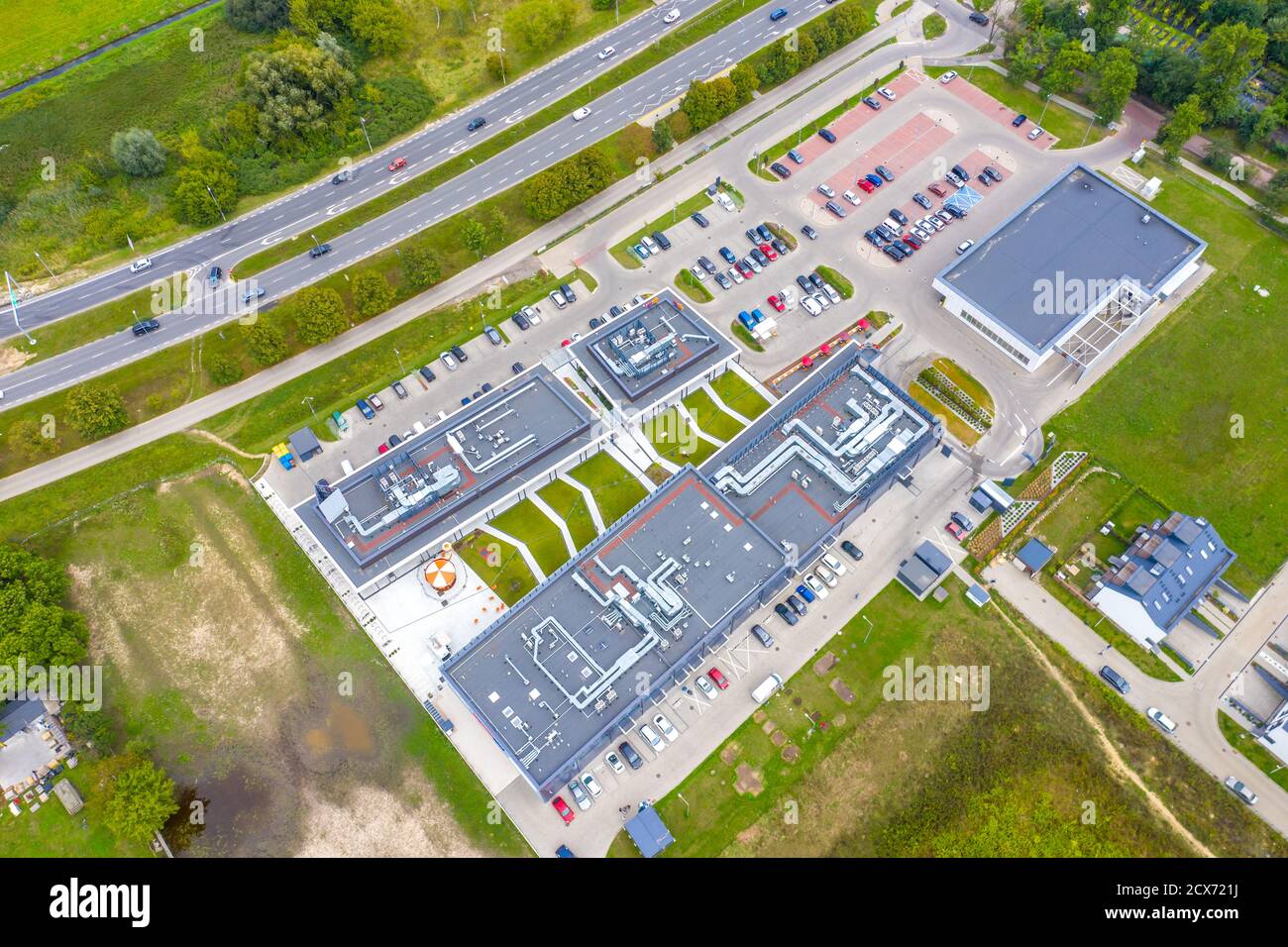 Einkaufszentrum oder Einkaufszentrum und Parkplätze für Autos. Stadtparkplatz mit verschiedenen Autos. Baumbereich. Parkzone Draufsicht mit verschiedenen Fahrzeugen. Stadtleben. Stockfoto