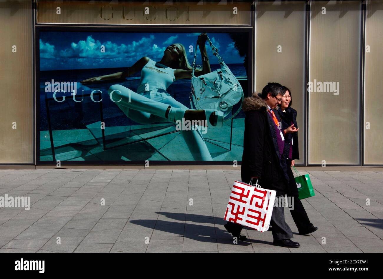 7. Dezember 2010 vorbeigehen Shopper ein Plakat für das Modelabel Gucci im  Zentrum Pekings. Geschäftliche Stimmung an der asiatischen Spitze, dass  Unternehmen im vierten Quartal als Kapitalgesellschaften erholte sich  abgetan Bedenken, dass