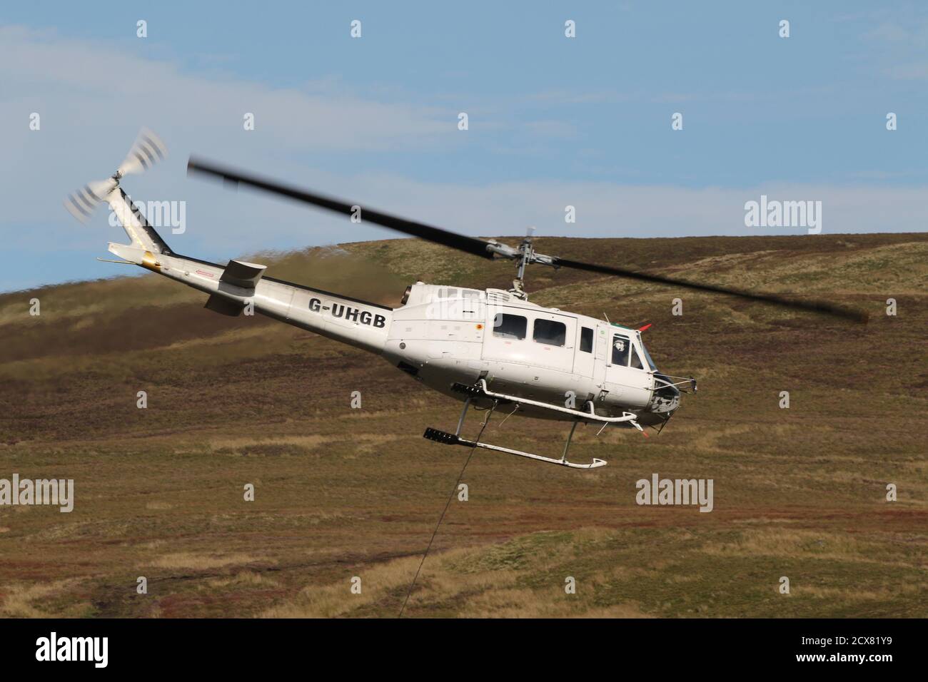 G-UHGB, eine Bell 205A-1, die von Heli-Lift Services betrieben wird, führt Pylonen-Abbauarbeiten in den Hügeln von Renfrewshire/Inverclyde in Schottland durch. Stockfoto